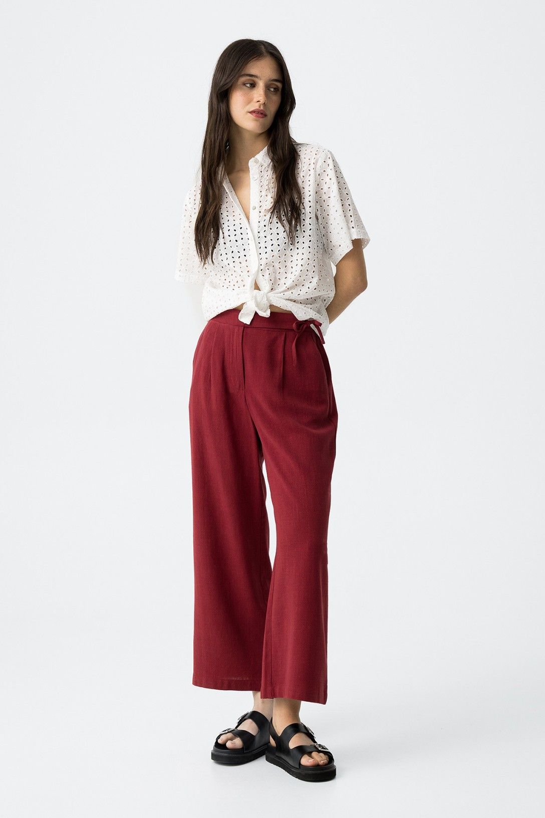 "Donna indossa Pantalone Capri JULIE amarena in lino e viscosa, vista frontale completa con camicia bianca traforata, sandali neri, look elegante"