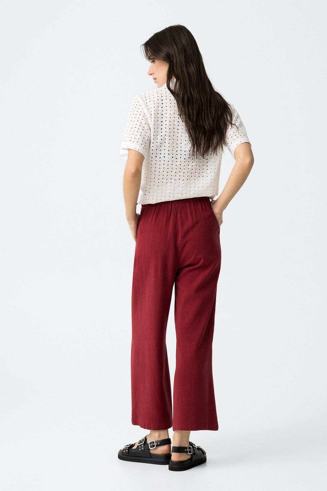 "Vista posteriore Pantalone Capri JULIE amarena in lino e viscosa, mostra vestibilità comoda e taglio wide leg, con camicia bianca traforata"