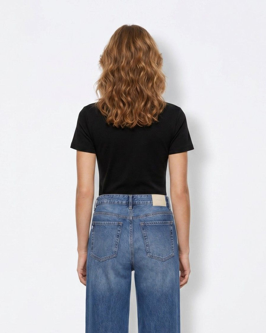 T-shirt donna nera Tiffosi Kariz – vista posteriore con jeans wide leg denim, silhouette aderente su sfondo bianco
