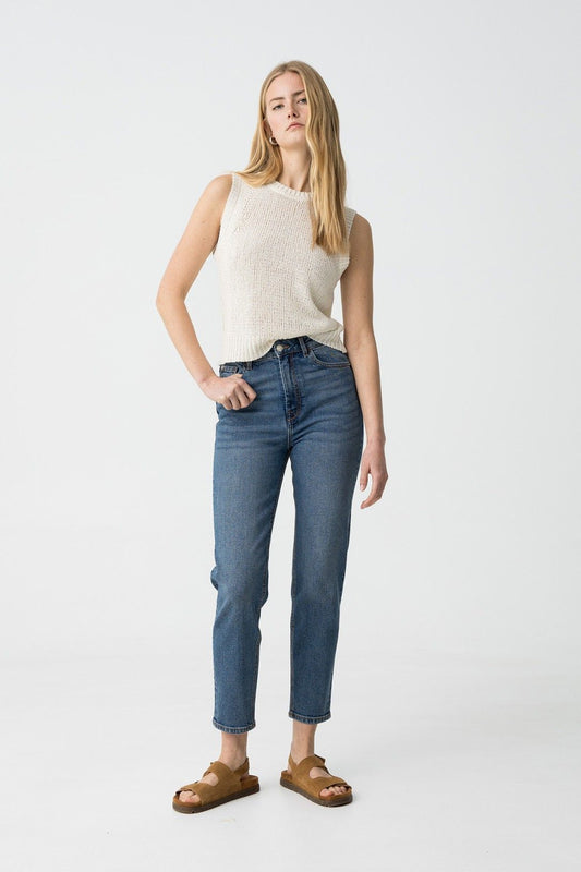 "Donna che indossa jeans Mom_Slim_39 blu denim a vita alta con top bianco senza maniche, vista frontale completa"