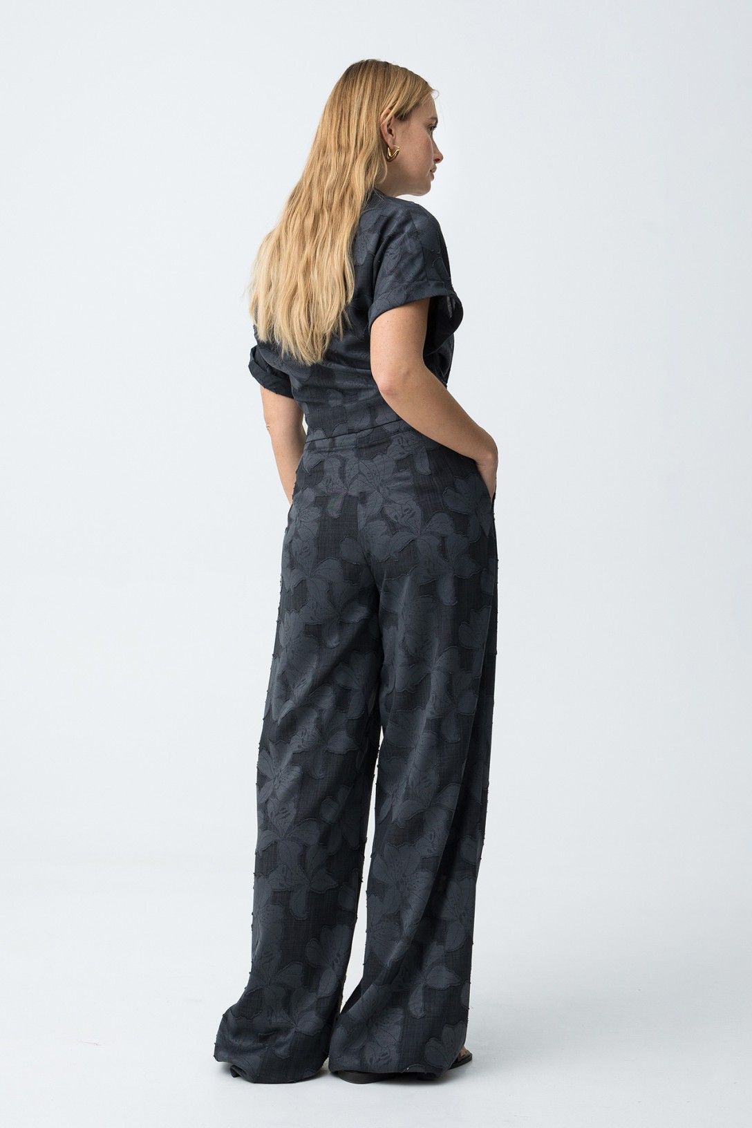 Vista posteriore completo donna fantasia floreale opera elegante, camicia fiocco e pantalone palazzo