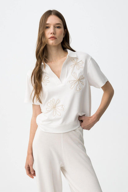 Polo donna ricamo floreale Philly bianca con ricamo floreale sul petto, mezza manica e scollo a V - dettaglio frontale