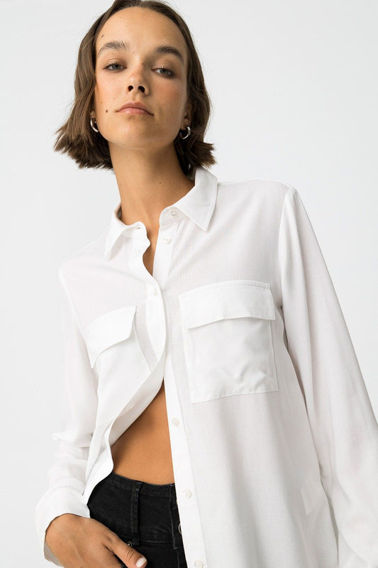 Dettaglio camicia Tiffosi bianca con colletto classico e abbottonatura frontale, modella con capelli corti e orecchini
