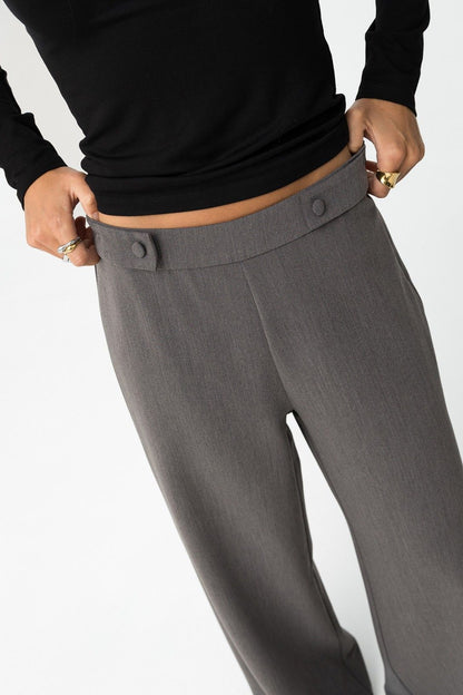 Primo piano pantalone Sammy_1 grigio - dettaglio vita alta con bottoni decorativi e vestibilità wide leg abbinato a top nero