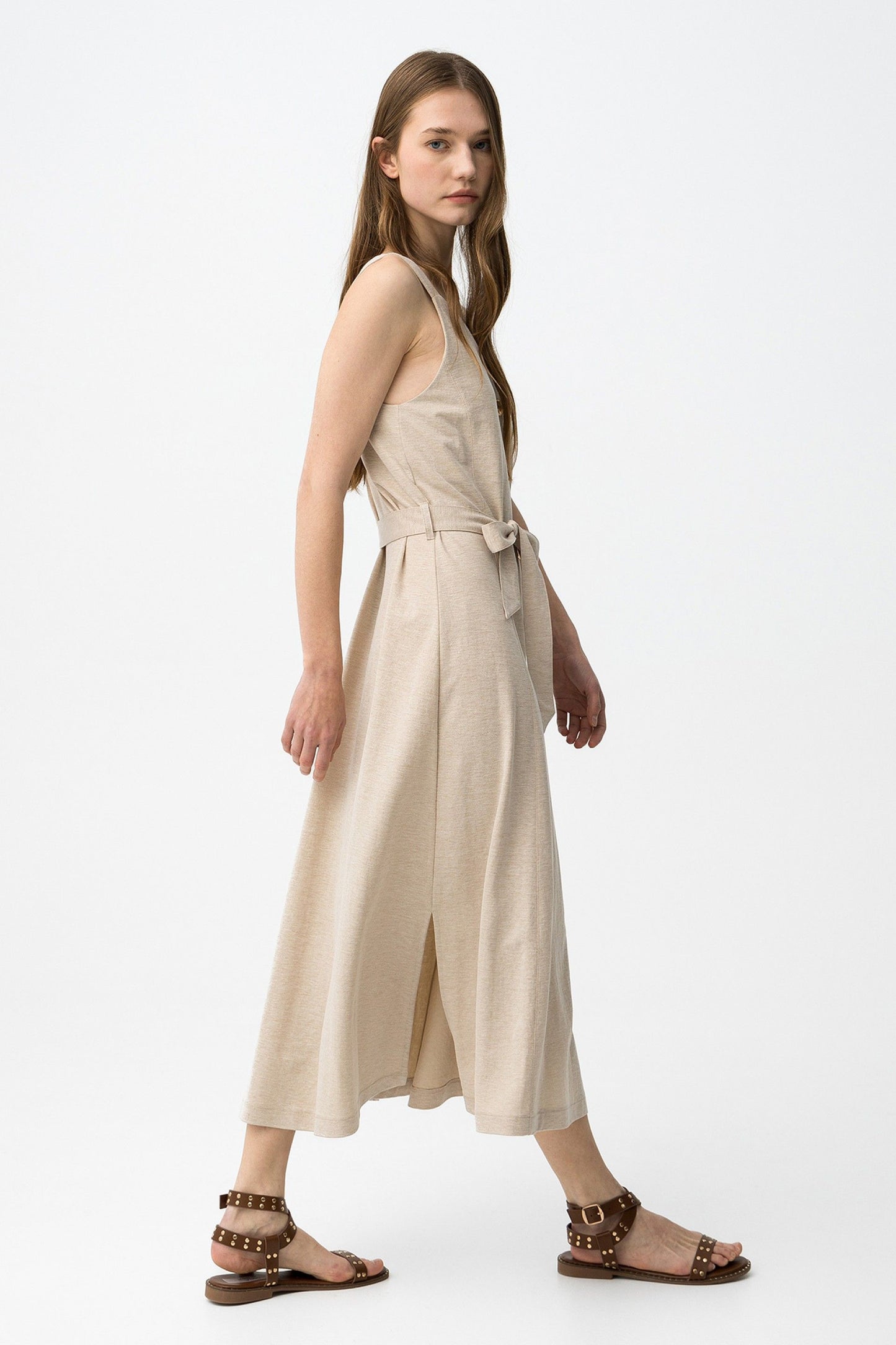 Abito donna Shara maxi  beige indossato di profilo – silhouette fluida e lunghezza maxi, taglio regolare